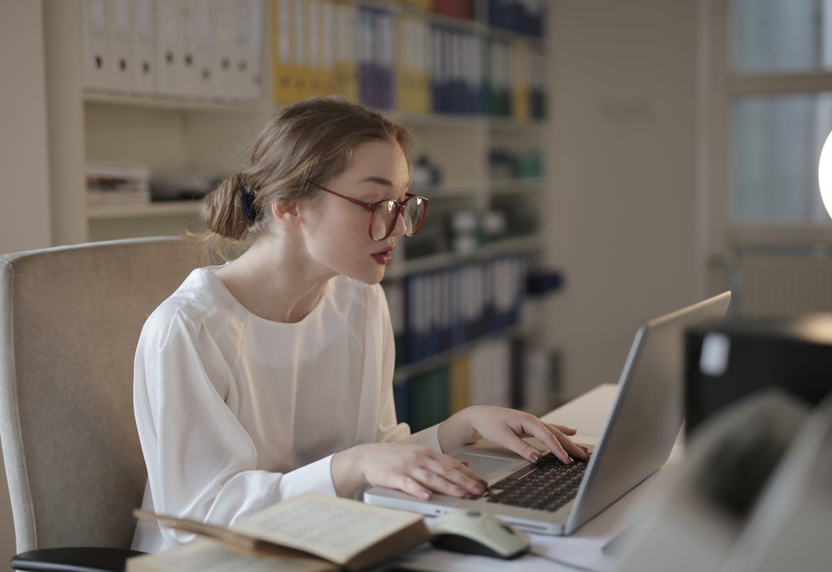 Office worker focused at a laptop weighing the career impact of accepting a promotion offer